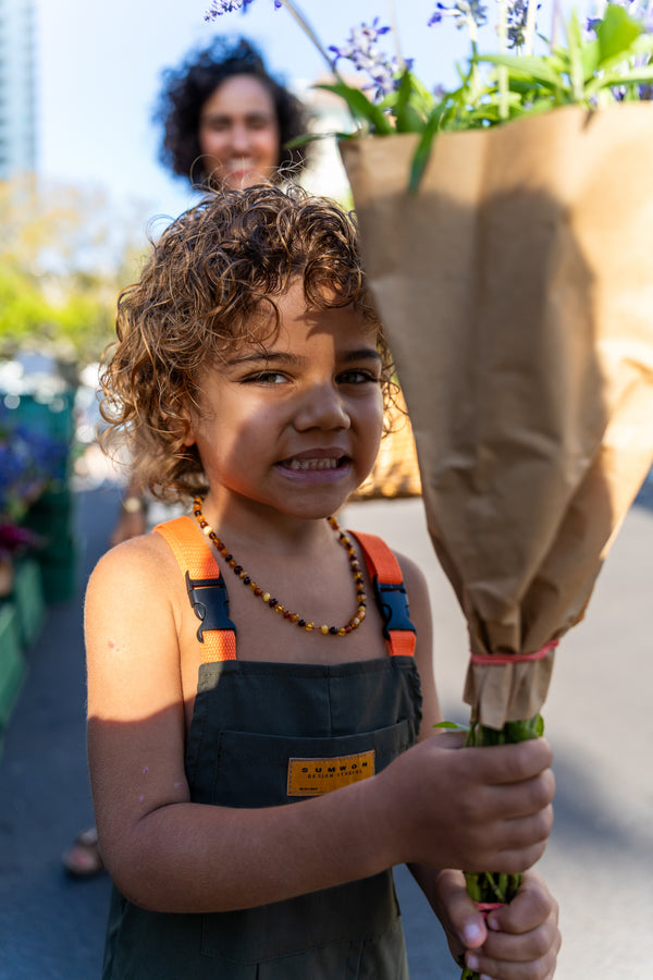 Hannah Chehab's child smiling beside her with flowers